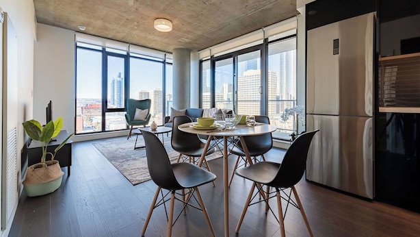 Una cocina moderna con comedor, ventanas amplias y vistas a la ciudad.