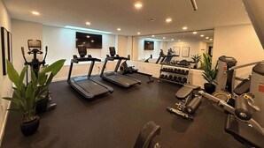 A modern gym with treadmills, dumbbells, and exercise equipment. - Bright, warm & spacious 1 BR in North End Halifax (Halifax)