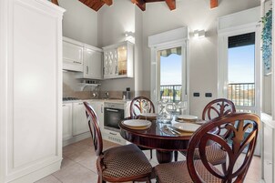 A dining area with a round table, chairs, and a view of the outdoors.