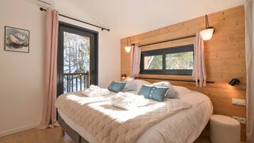 Une chambre à coucher avec un lit, une fenêtre, un mur en bois et un luminaire au plafond.