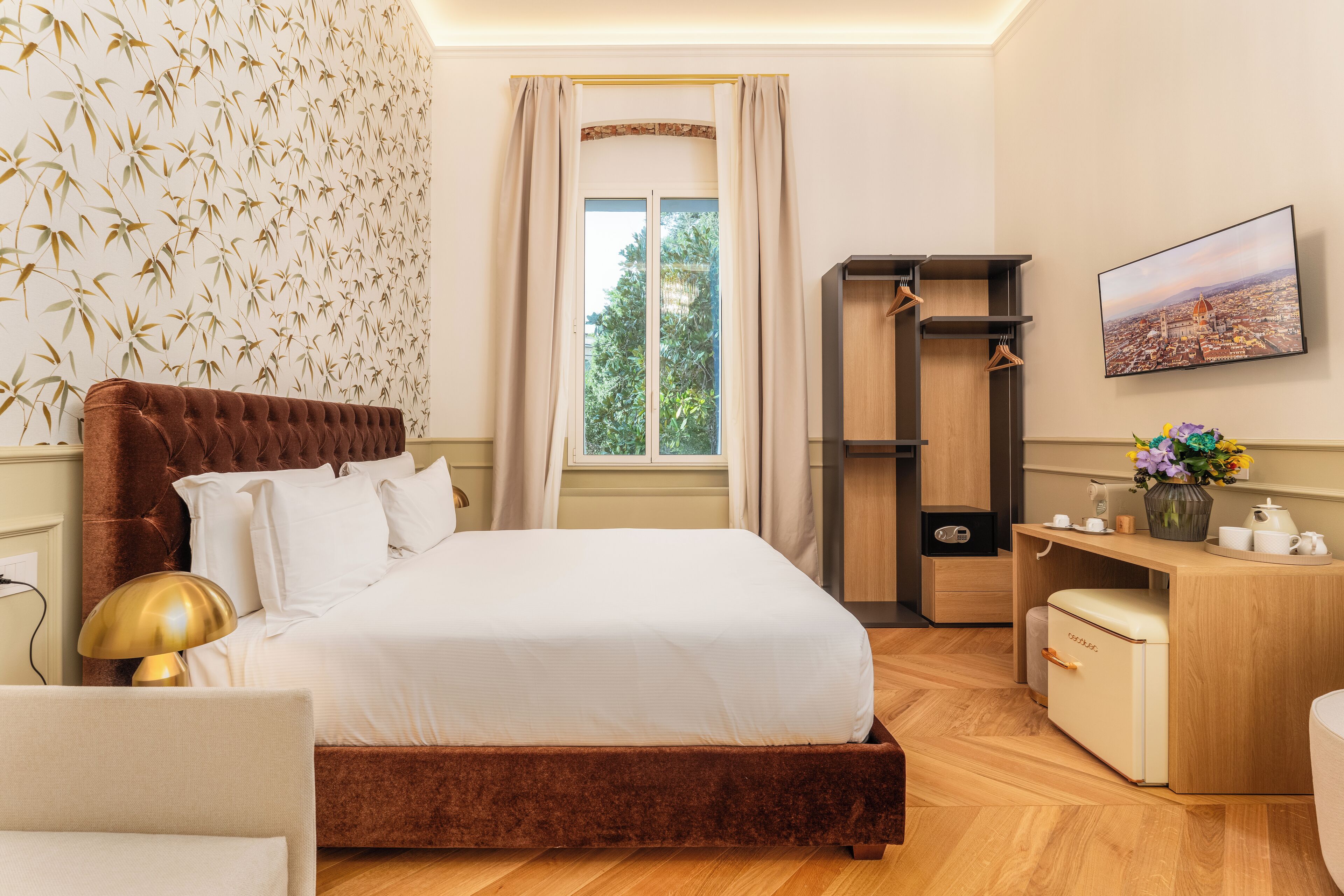 Una camera da letto con un letto grande, una scrivania, un armadio e una finestra vista verde.