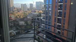 A high-rise building with multiple floors, a balcony, and a view of the surrounding cityscape. - Batumi Inn (Batumi)