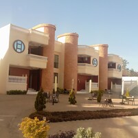 Un edificio con varios balcones, un patio central y zonas de estar al aire libre.