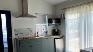 Una cucina moderna con cappa aspirante in acciaio inossidabile, forno a microonde e lavastoviglie.