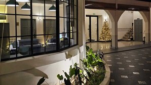 Un edificio moderno con grandes ventanales, un árbol de Navidad y un interior bien iluminado.