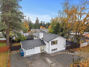 Ein Wohnhaus mit Garage, umgeben von Bäumen mit Herbstlaub.