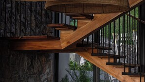 Eine moderne Treppe mit Holelllaufgeländern und einer Steinsäule.