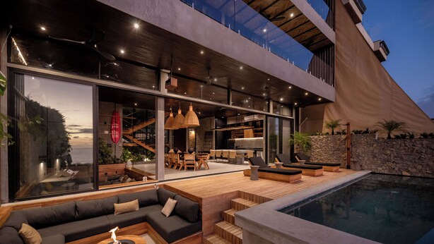 Ein moderner Außenbereich mit Pool, Holzterrasse und Sitzgelegenheiten.