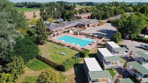 An aerial view of a campground with a swimming pool, RVs, and mobile homes. - Hotiday Bologna Arena (Bologna)