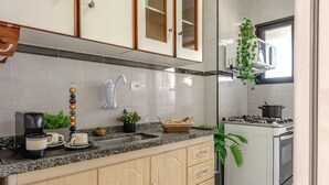 Eine Küche mit Granitabdeckung, Holzausbau, integriertem Backofen und Gasherd.