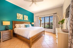A bedroom with a wooden bed, teal walls, and a large window with curtains. - Oceanview Retreat - Sunrise Tamarindo (Tamarindo)
