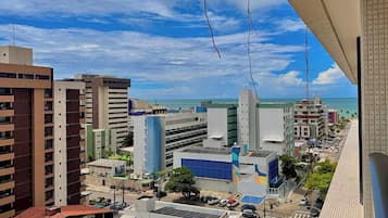 A cityscape with high-rise buildings, a clear sky, and a view of the ocean.