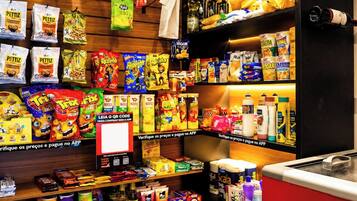 A variety of snack and household items on shelves and a checkout counter.