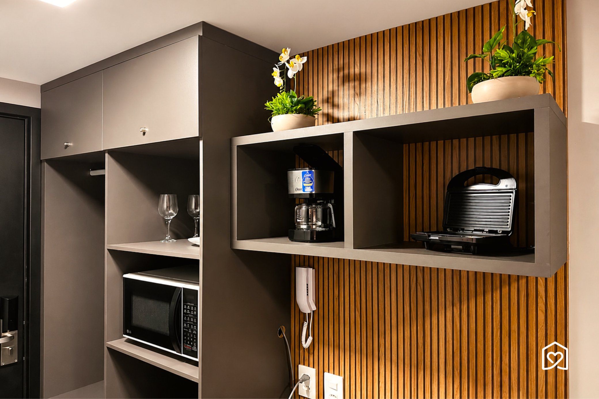Een moderne keuken met inbouwapparatuur, een koffieapparaat en een telefoon.