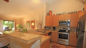 A kitchen with wooden cabinets, a stainless steel refrigerator, a microwave, and an oven. - 2 Bedroom at Woodhaven Country Club in Palm Desert. (Palm Desert)