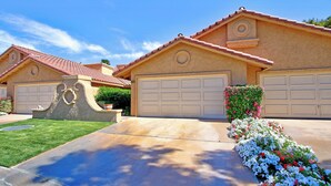A residential house with a garage, a well-maintained lawn, and a flower bed. - 2 Bedroom at Woodhaven Country Club in Palm Desert. (Palm Desert)