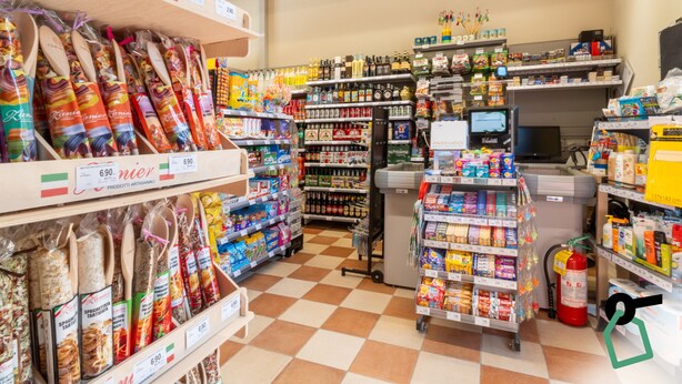 A grocery store interior with shelves stocked with various products, a checkout area, and a fire extinguisher. - Hotiday Lodge Viareggio (Viareggio)