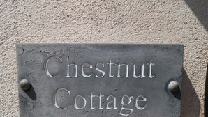 A sign with the words "Chestnut Cottage" mounted on a textured wall. - Chestnut Cottage (Bridlington)