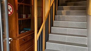 A staircase with a wooden handrail and a glass door on the left.