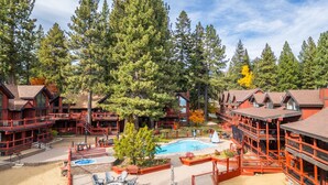 A lodge with multiple wooden buildings, a swimming pool, and a well-maintained outdoor area. - Relaxed Lakefront Living • Cozy 1BR Tahoe Condo (Tahoe Vista)