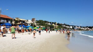 Une plage avec des parasols et des gens.