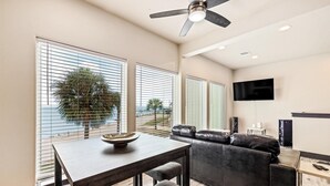 Un salon moderne avec une table à manger, un canapé en cuir et un ventilateur de plafond.