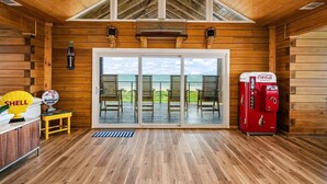 Eine Holzhütte mit einem großen Schiebeglastür, die auf eine Terrasse mit Blick auf den Strand führt.