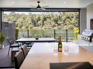 Un coin repas avec une table, des chaises et une bouteille de champagne.
