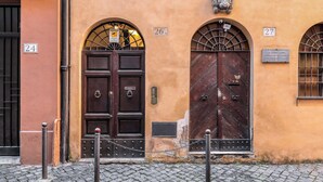 Un bâtiment doté de deux grandes portes en bois, numérotées 26 et 27, et d’une petite plaque fixée au-dessus de la porte de droite.