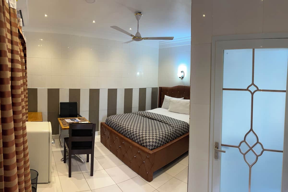 A modern bedroom with a bed, a desk, and a chair.