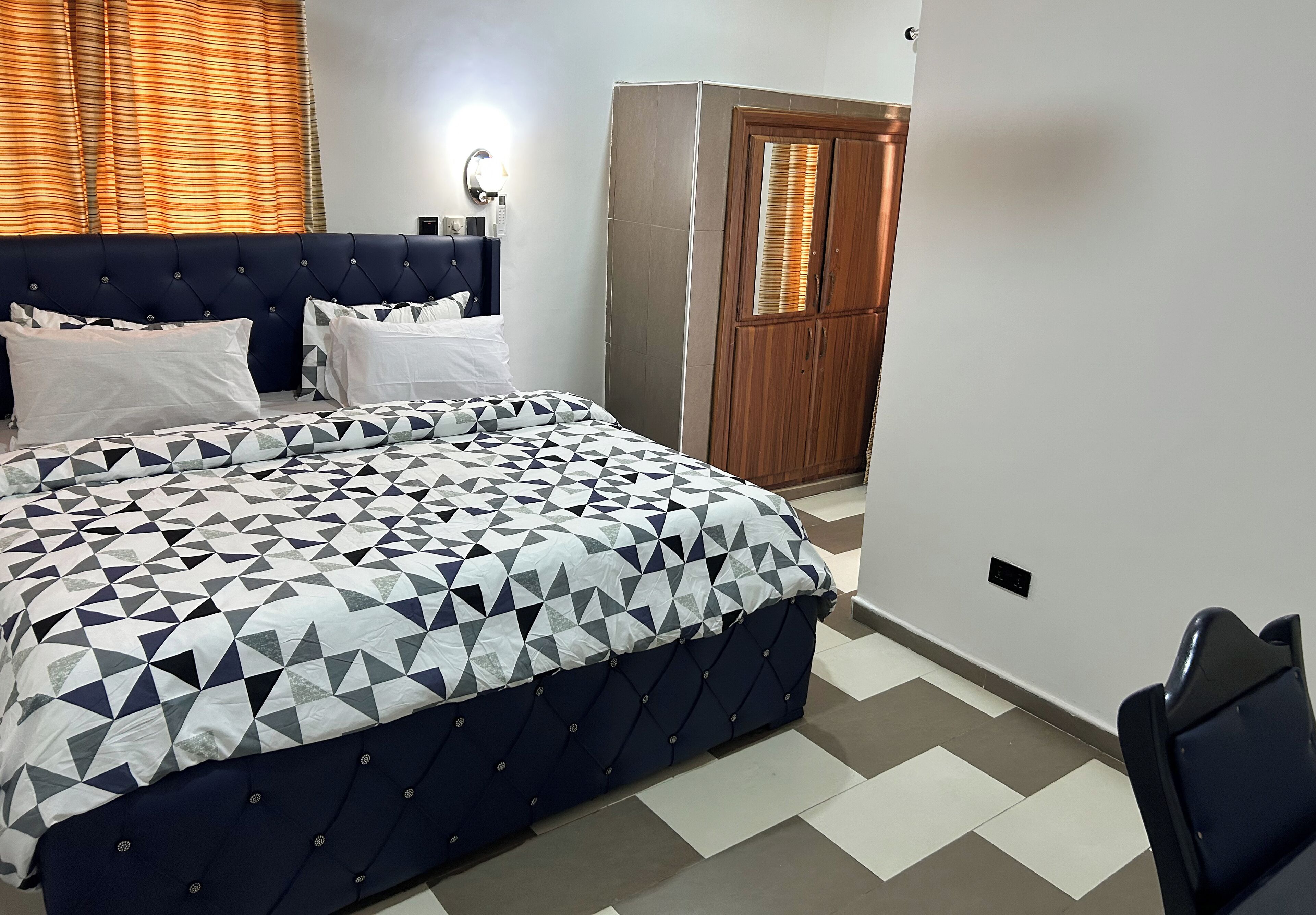 Un dormitorio con una cama, un armario y una mesita de noche.