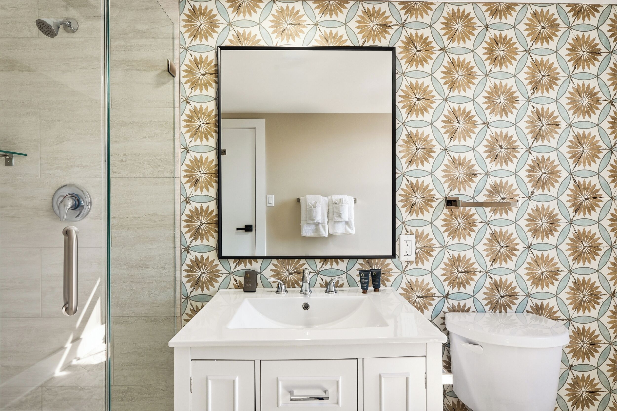 A bathroom with a white sink, a mirror, and a toilet.