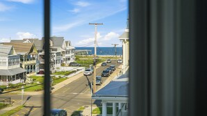 A coastal street with buildings, a clear sky, and a view of the sea. - The Marilyn Inn (Ocean Grove)