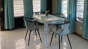 Un espace repas comprenant une table, des chaises et un ventilateur de plafond.