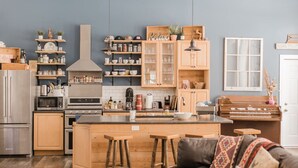 Una cocina moderna con armarios de madera, una isla central y taburetes de bar.