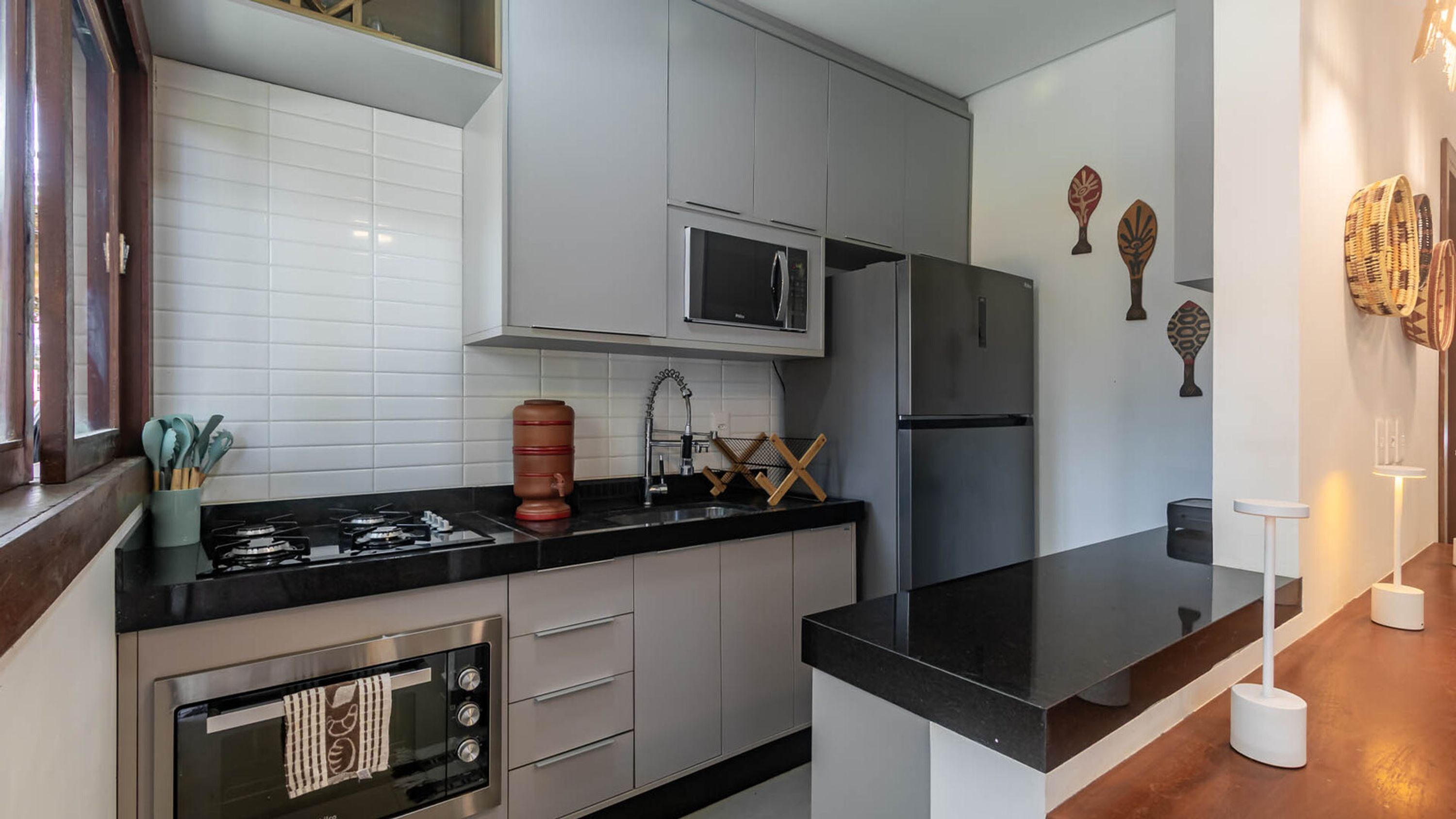 A modern kitchen with a black countertop, stainless steel appliances, and white cabinetry.