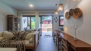 Una sala moderna con sofá, mesa de comedor y zona de cocina.