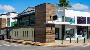 A modern building with a wooden facade and a glass entrance. - Loft com Smart Lock e Ar Perto do Projeto Tamar (Ubatuba)
