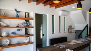 Un área de recepción con estantes de madera que exhiben objetos decorativos, un mostrador de recepción y una escalera.