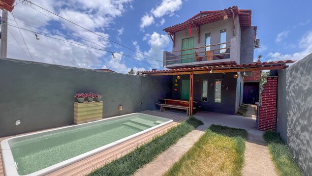 A two-story house with a patio, a swimming pool, and a small deck area. - Casa Brisa das Guas Piscina e Churrasqueira (Porto de Pedras)