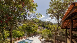 A pool area with a clear view of the pool, surrounded by lush greenery and trees. - Casa com Piscina Sal o de Jogos e Churrasqueira (Mairipora)