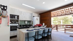 Une cuisine moderne dotée d’un îlot central, d’appareils électroménagers intégrés et d’un coin repas avec des chaises.