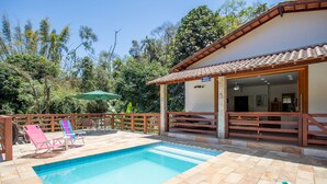 Une piscine avec des chaises longues et une terrasse en bois.