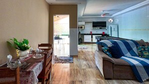 Ein modernes Wohnzimmer mit Sofa, Esstisch und Küchenbereich.