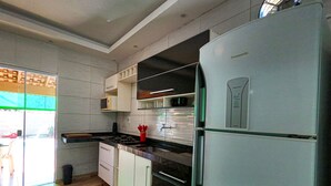 Eine moderne Küche mit weißen Schränken, einem Edelstahlkühlschrank und einem eingebauten Backofen.