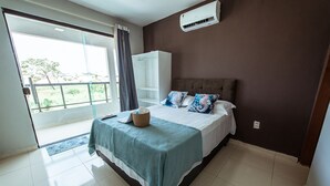 A bedroom with a bed, a wardrobe, a window with curtains, and an air conditioning unit. - Casa em Jacum com Piscina 5 Suites e Fliperama (Conde)