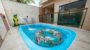 A swimming pool with a decorative inflatable ring and a water spout. - Casa em Jacum com Piscina 5 Suites e Fliperama (Conde)