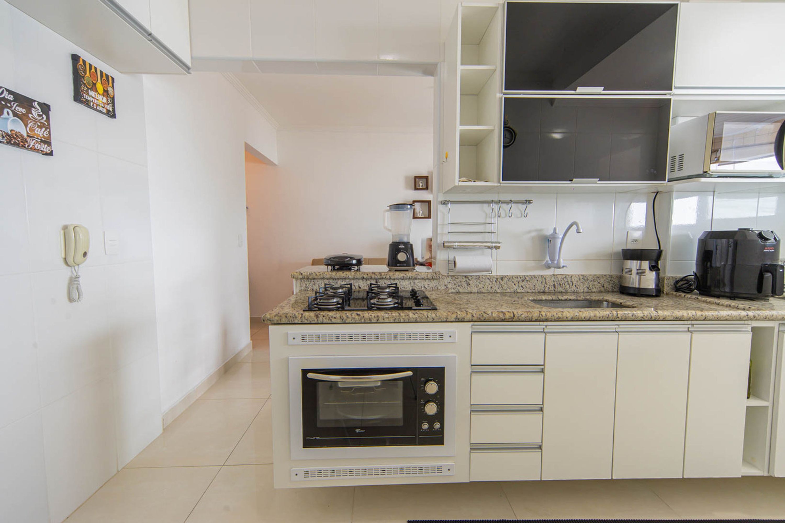 Cozinha moderna com forno embutido, micro-ondas e fogão a gás.