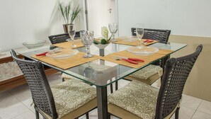 En matplats med ett glasbord, bekväma stolar och en krukväxt.