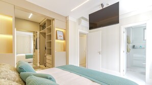 Ein modernes Schlafzimmer mit einem großen Bett, einem begehbaren Kleiderschrank und einem Badezimmer mit Dusche und Toilette.